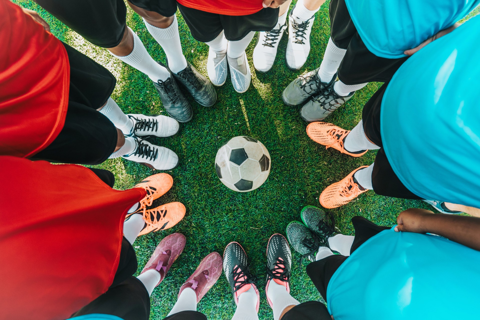 boy soccer team standing in circle around soccer ball